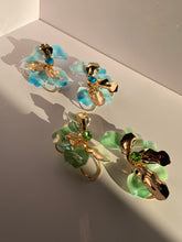 Oversized aqua blue floral statement earrings with translucent petals gold-tone accents and sparkling blue centers