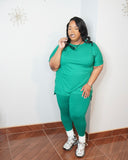Plus size woman wearing emerald green legging set styled with sunglasses and sneakers