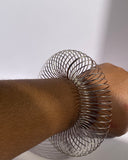Silver minimalist wire coil bracelet worn closed for sleek everyday look