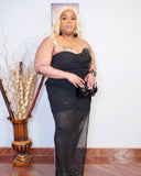 Side angle of black plus size sequin dress with sheer flowing overlay and slit detail