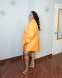 Side view of plus size orange shirt dress showing flowy fit and tie detail
