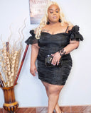 Side angle of plus size black taffeta dress showing fitted silhouette and ruffle sleeves