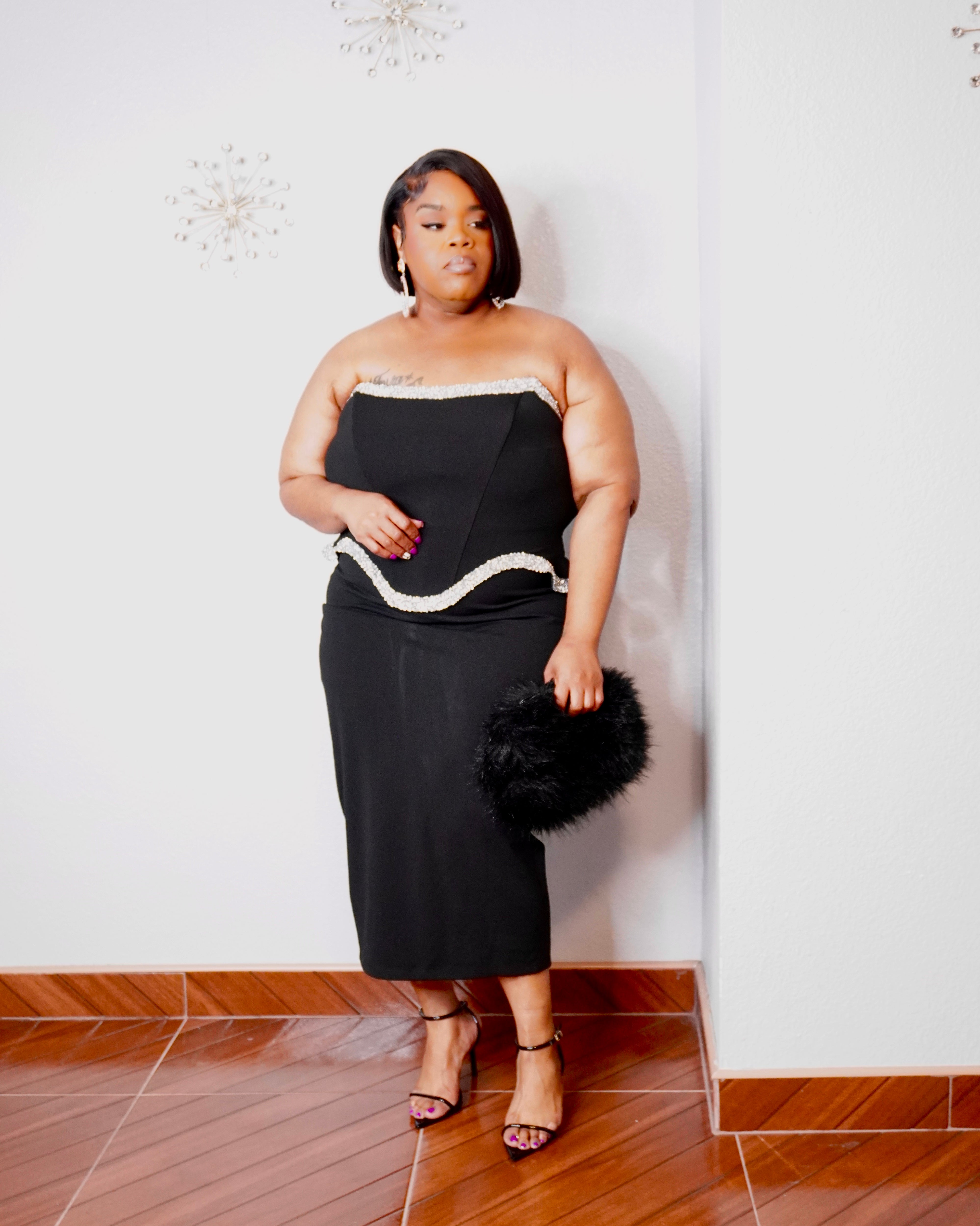 Plus-size model wearing LYSAIRE Celeste black strapless corset midi dress with sparkling silver-tone trim.