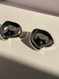 Silver-tone chunky geometric stud earrings featuring softly rounded square shapes and polished mirror-like surfaces