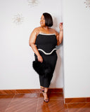 LYSAIRE elegant black strapless midi dress styled with black heels and a statement faux-fur handbag.
