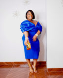 Plus size royal blue evening dress with thin shoulder straps, deep V neckline, oversized draped sleeves and gold clutch.