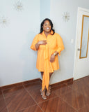 Plus size model wearing orange tie front shirt dress front view with heels