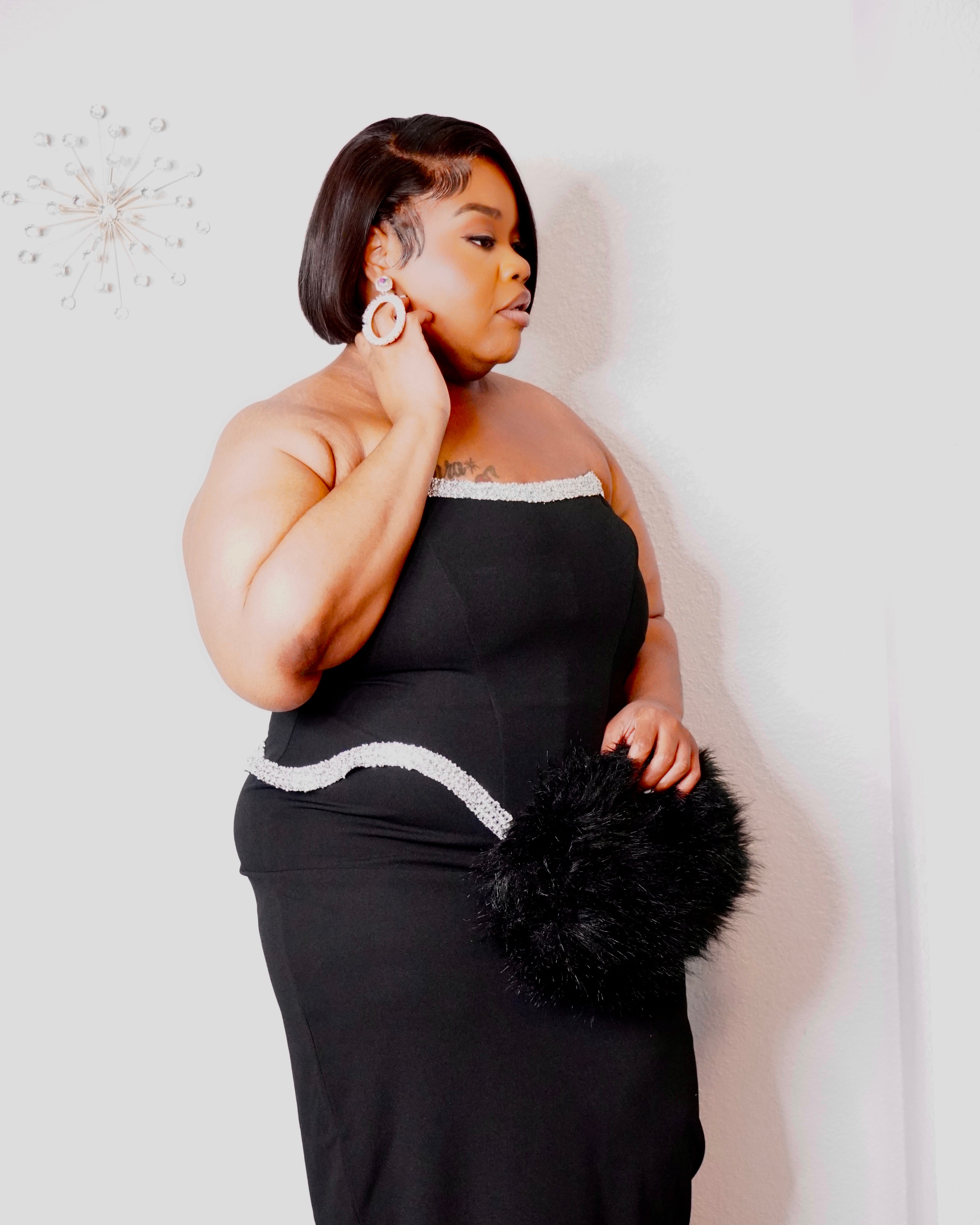 Close-up of black plus-size corset-inspired dress with sparkling silver-tone trim along the neckline and sculpted waist.