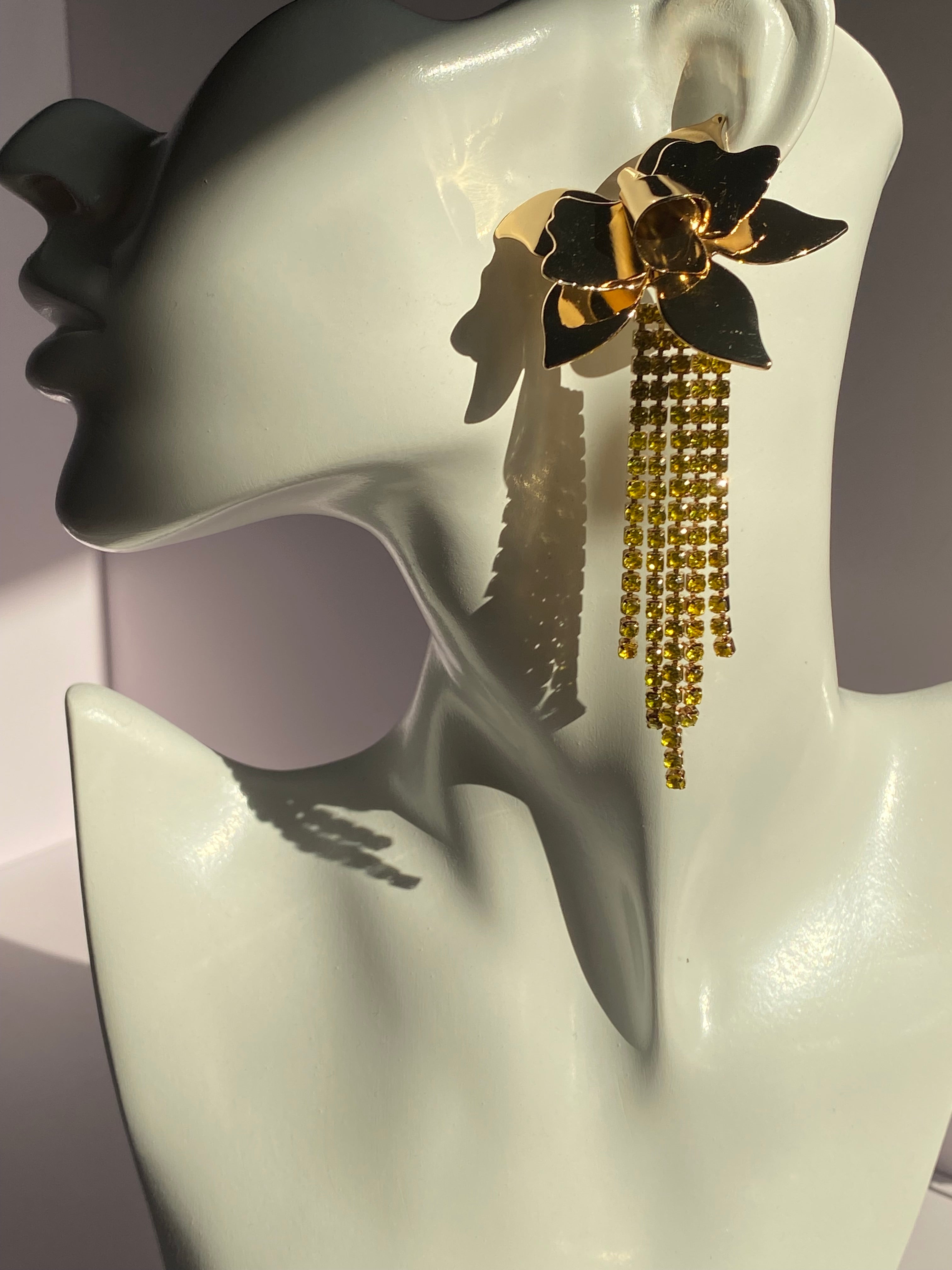 Oversized gold floral earring with polished flower petals and sparkling golden-yellow rhinestone fringe