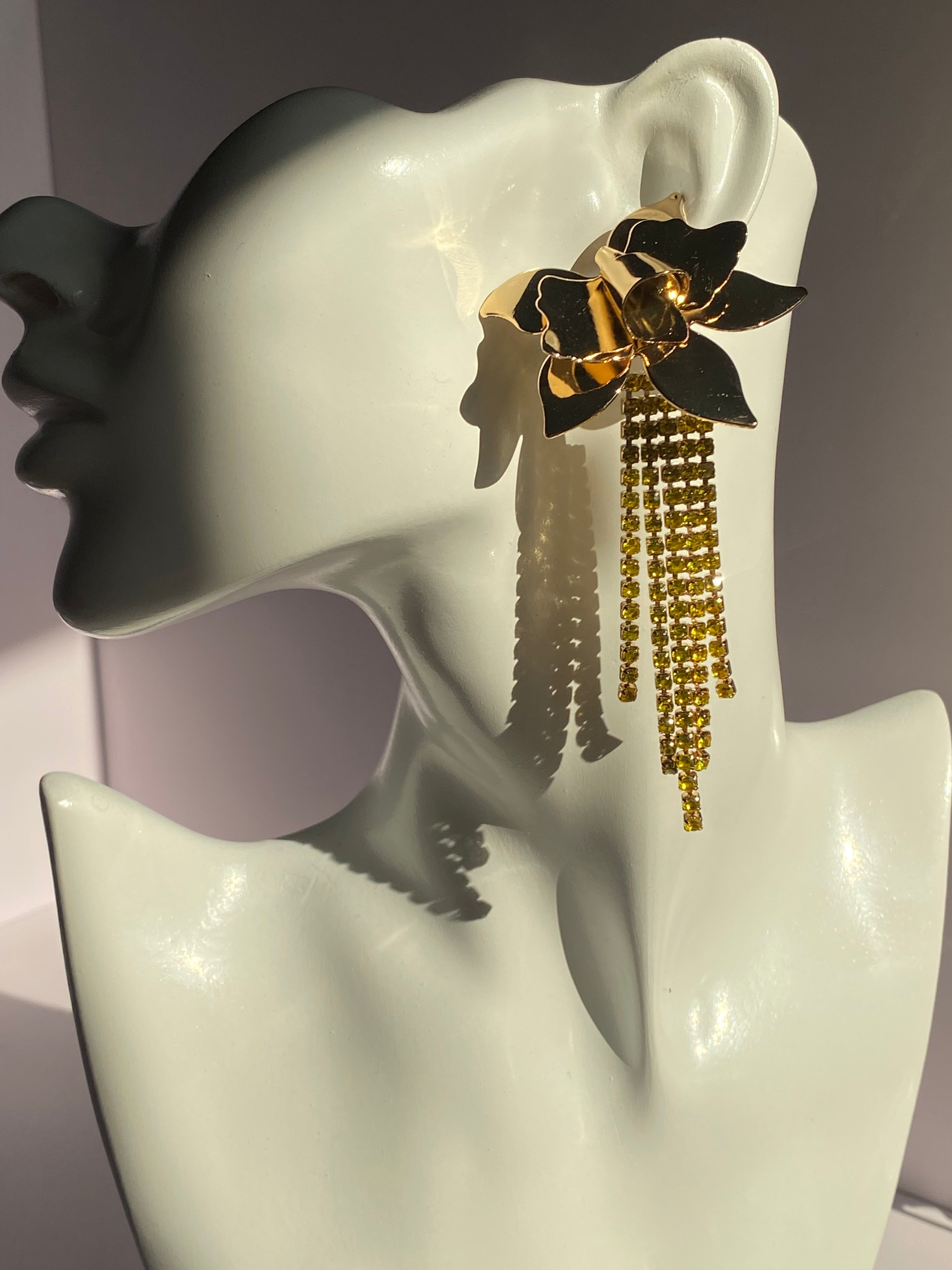 Long gold flower rhinestone tassel earring with cascading yellow crystal-style strands displayed on jewelry mannequin