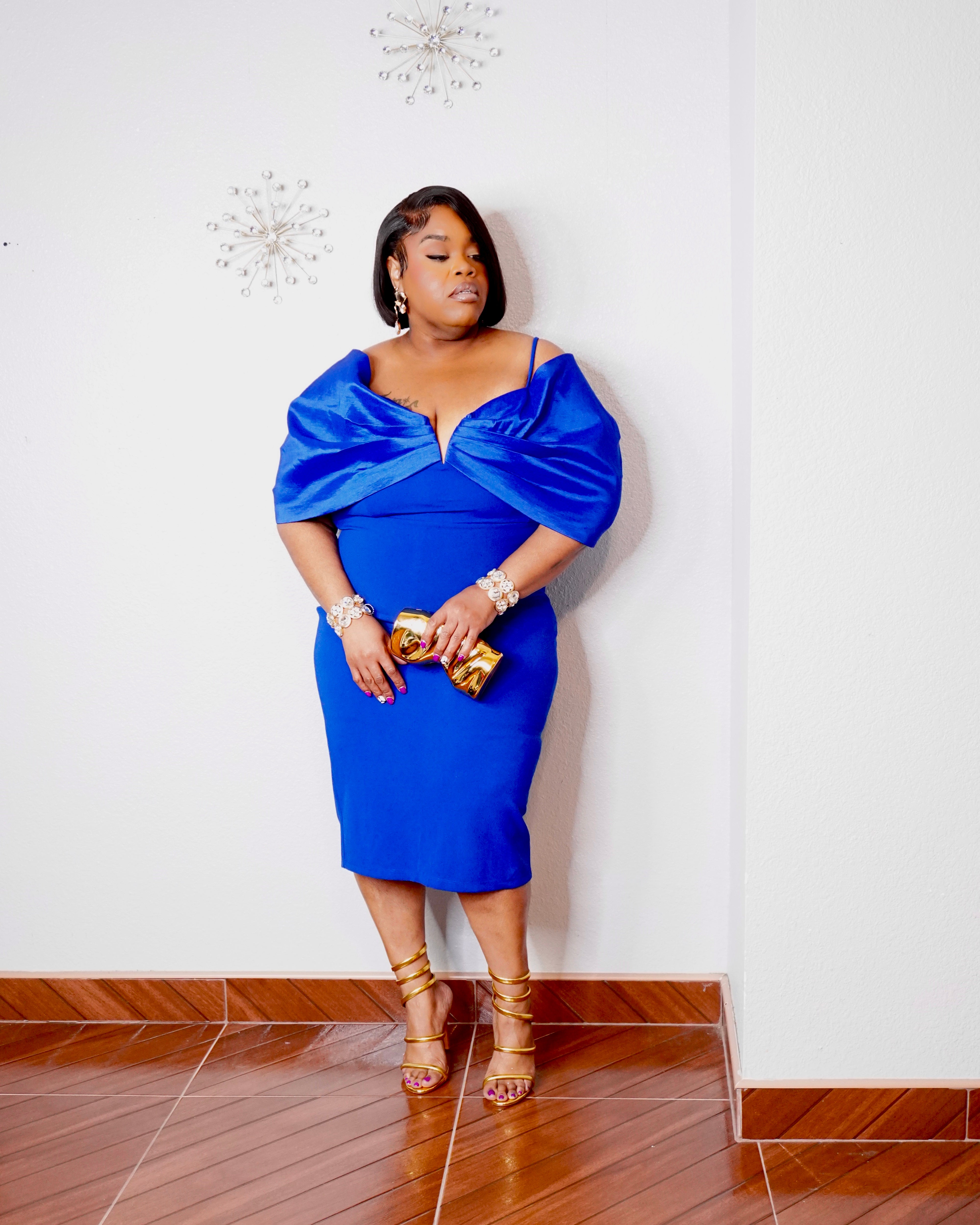 LYSAIRE royal blue fitted midi dress showcasing dramatic satin-like shoulder draping, spaghetti straps and a flattering pencil silhouette.