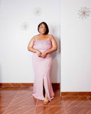 Full-length front view of the Rosé Royale dusty pink plus size evening gown from LYSAIRE, showcasing the intricately embellished pink bodice, square neckline, fitted silhouette, floor-length maxi skirt, and dramatic front slit, modeled with gold strappy heels for an elegant formal occasion look.
