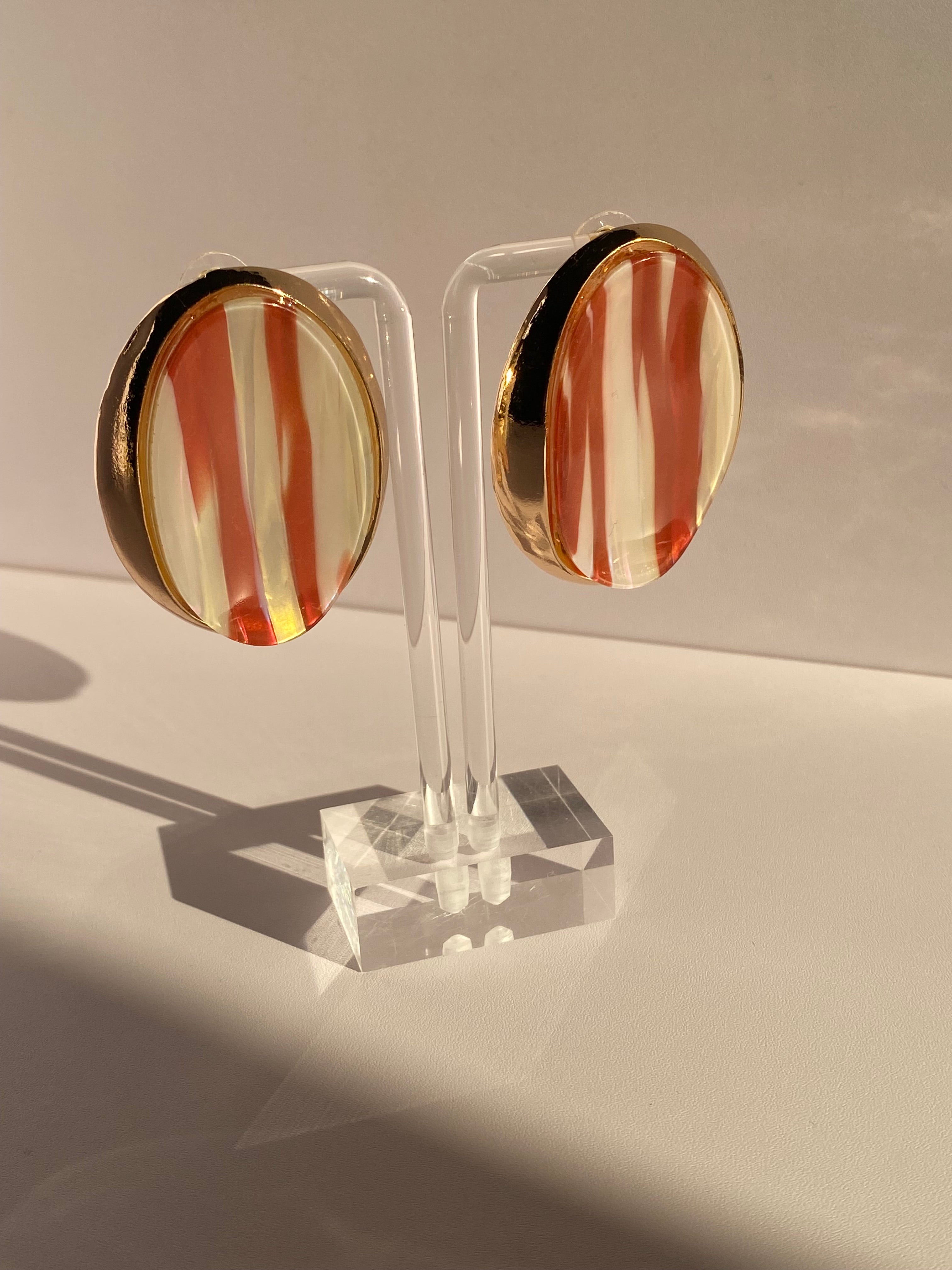 Vintage-inspired oval statement stud earrings with glossy amber orange and cream striped centers and gold-tone borders