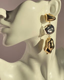 Gold and silver mixed metal abstract drop statement earring displayed on jewelry bust