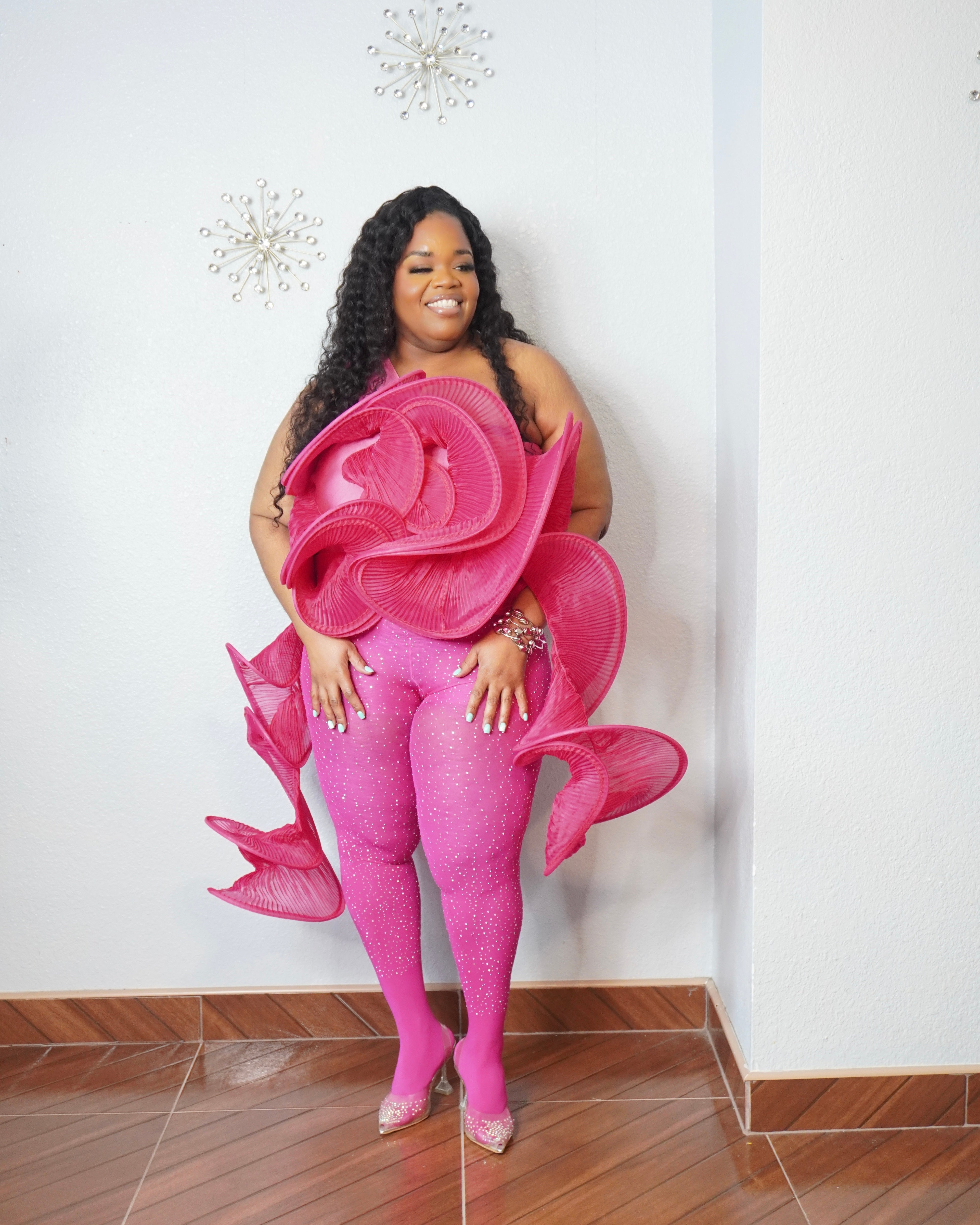 Plus size fuchsia pink one shoulder sculptural ruffle top styled with rhinestone leggings