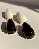 Oversized ivory teardrop statement stud earrings featuring glossy finish and delicate gold-tone edging