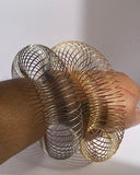 Gold and silver expandable wire cuff bracelets worn on wrist showing open statement style