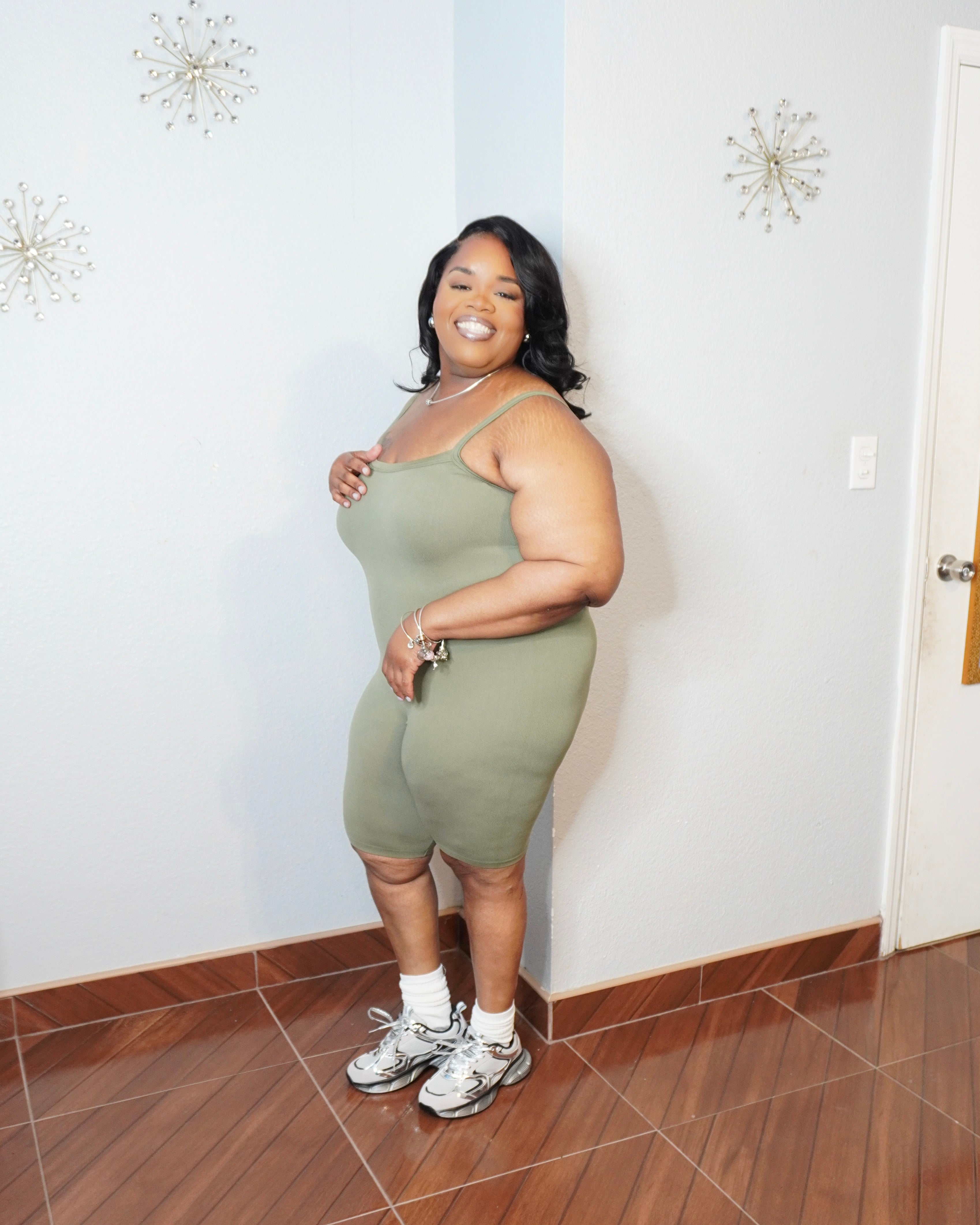 Side view of plus size olive biker romper highlighting stretch fabric