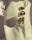 Gold and silver mixed metal abstract drop statement earring displayed on jewelry bust