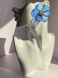 Oversized royal blue floral statement earring with transparent blue petals and gold-tone flower center