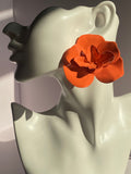 Oversized orange 3D flower statement earring featuring glossy sculpted petals and a dimensional floral design displayed on mannequin