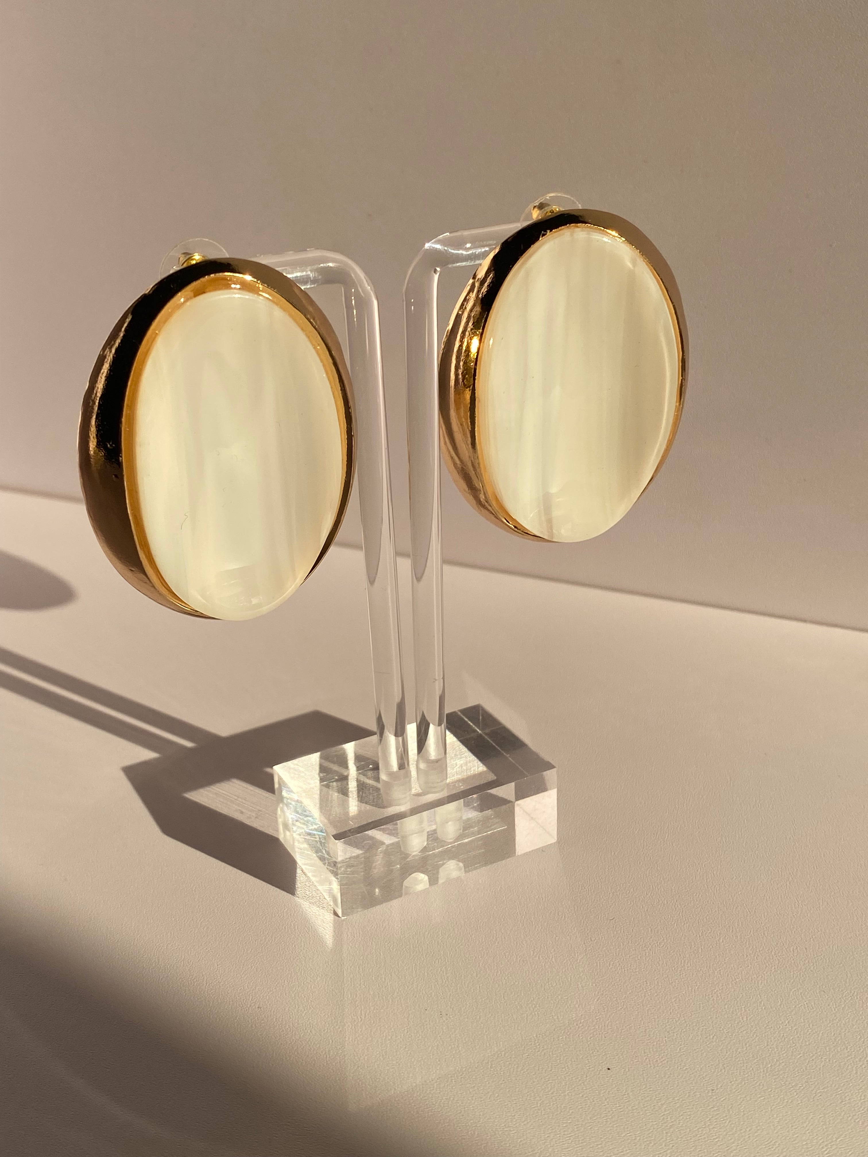 Oversized blush pink oval stud earring featuring a glossy striped centerpiece and bold gold-tone border