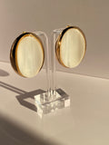 Oversized blush pink oval stud earring featuring a glossy striped centerpiece and bold gold-tone border