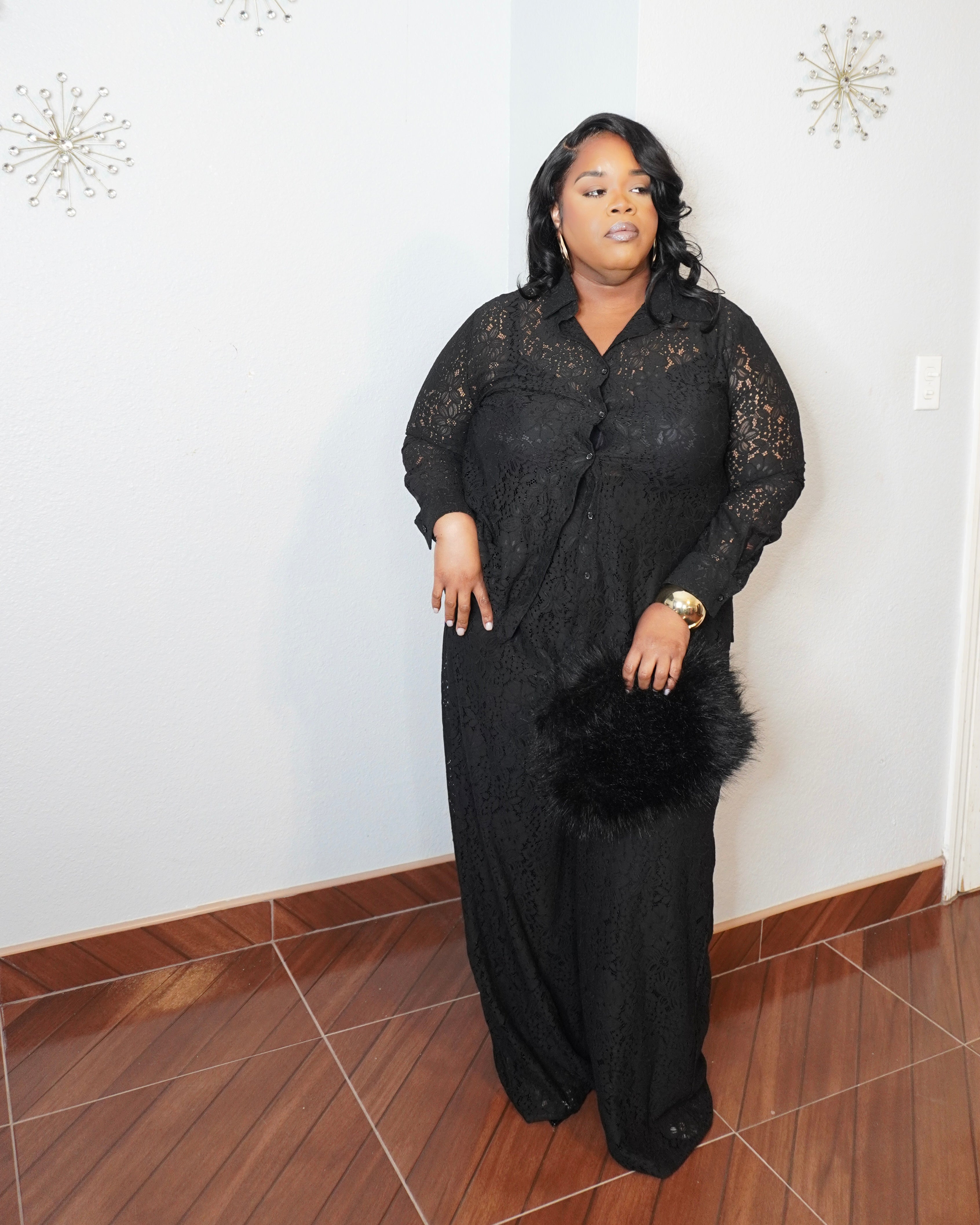 Plus size model posing in black lace wide-leg pant set with button-down blouse full body view