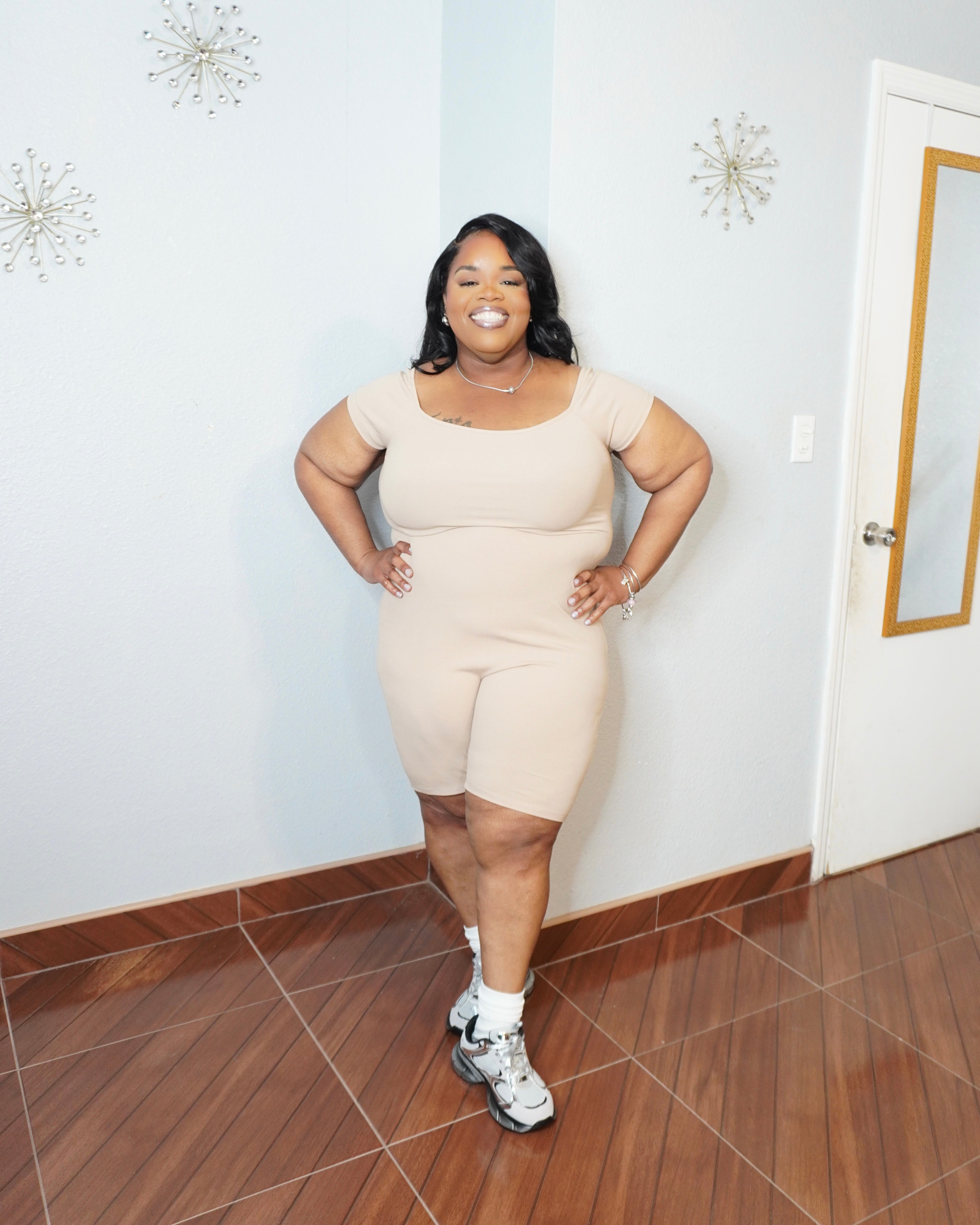 Plus size model smiling wearing basic romper styled casually
