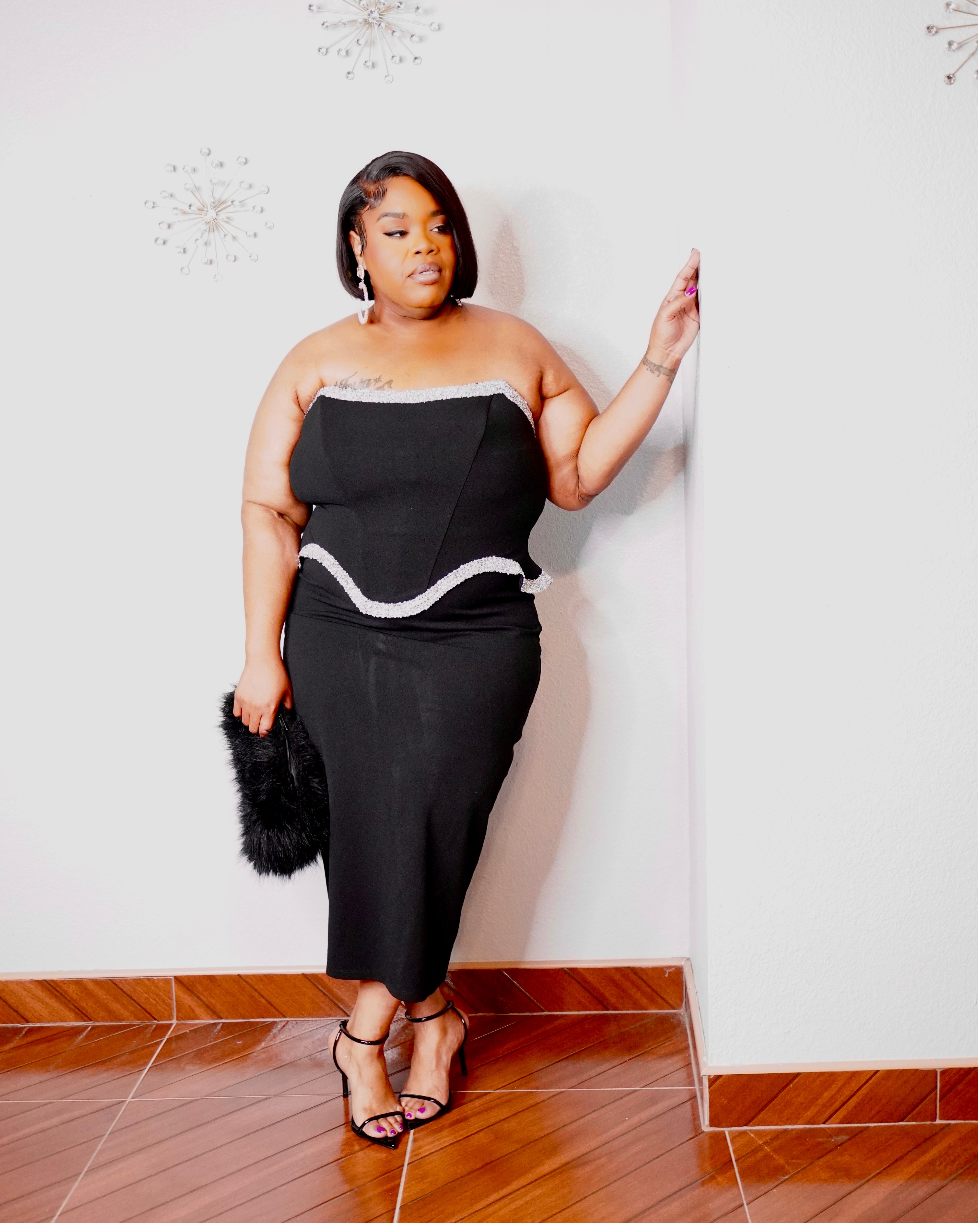 Black strapless plus-size cocktail dress with silver embellished corset-style waist and fitted midi skirt.