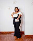 Plus-size woman wearing LYSAIRE black and white asymmetrical draped jumpsuit with wide-leg pants.