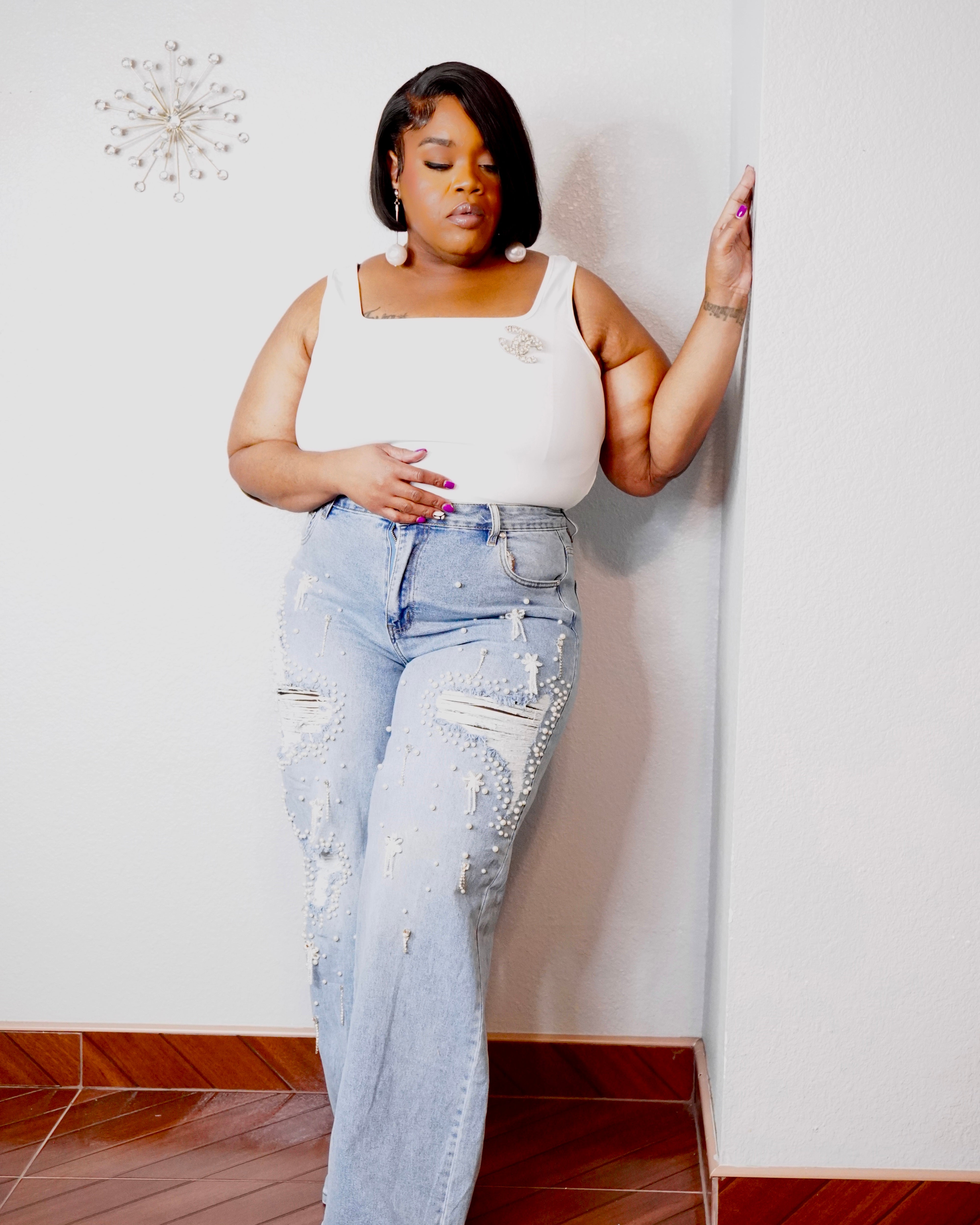 Curvy woman wearing light wash pearl detail jeans