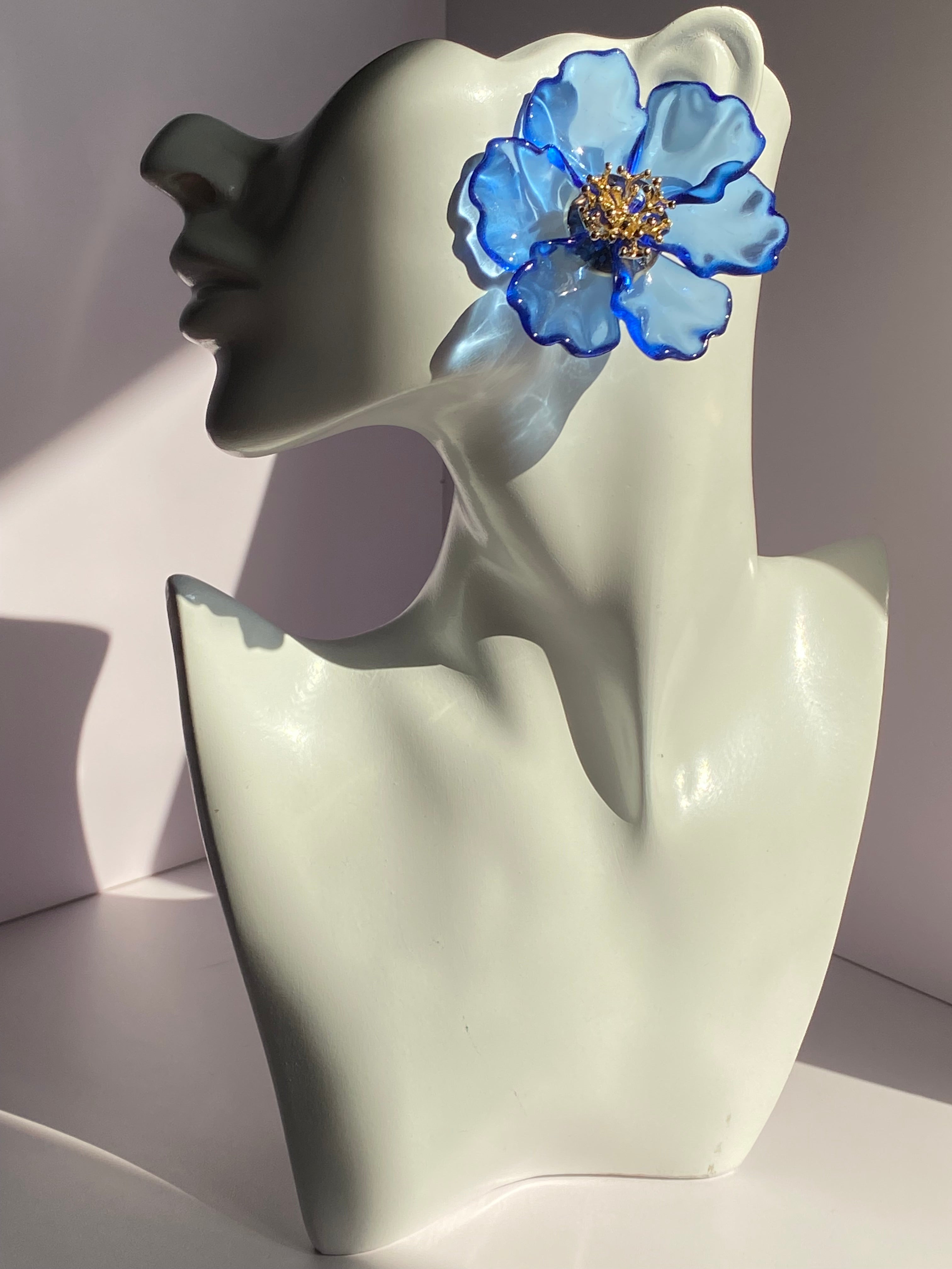 Oversized royal blue floral statement earring with transparent blue petals and gold-tone flower center