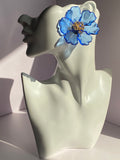 Oversized royal blue floral statement earring with transparent blue petals and gold-tone flower center