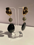 Black and gold leopard bead statement earrings featuring a three-part drop design with polished black oval pendants
